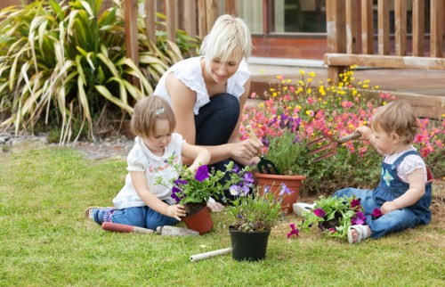 Gardener mowing a small Marylebone terrace lawn